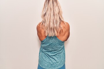 Middle age caucasian blonde woman wearing sportswear standing backwards looking away with crossed...