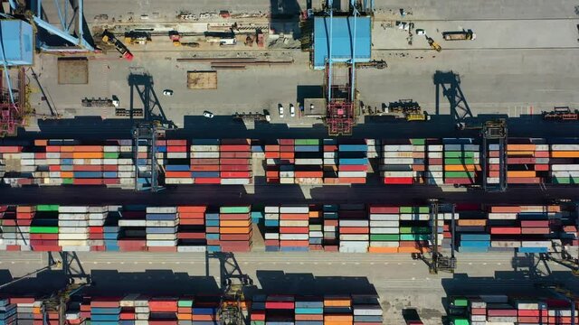 Drone shot of modern industrial port with containers from top view or aerial view. It is an import and export cargo port where is a part of shipping dock
