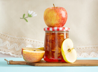 Jar of homemade apple jam and apples
