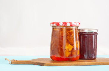 Two glass jars with apple and raspberry jam