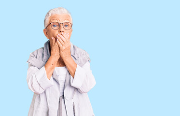 Senior beautiful woman with blue eyes and grey hair wearing casual clothes and glasses shocked covering mouth with hands for mistake. secret concept.
