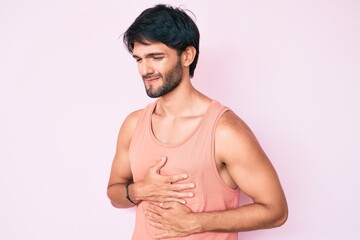 Fototapeta premium Handsome hispanic man wearing casual clothes with hand on stomach because indigestion, painful illness feeling unwell. ache concept.