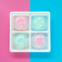 homemade two pieces jelly that were made in flower shap are in a white box on blue and pink background.