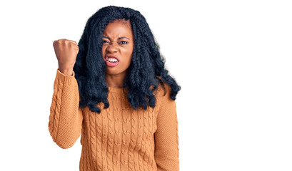 Beautiful african american woman wearing casual  sweater angry and mad raising fist frustrated and furious while shouting with anger. rage and aggressive concept.