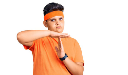 Little boy kid wearing sportswear doing time out gesture with hands, frustrated and serious face