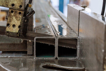 Cutting steel profiles on a band saw in production.