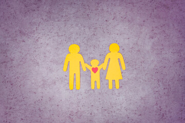 Silhouettes of yellow people cut out of paper. The family stands in a line and holds hands. The child loves his parents. Children's day.