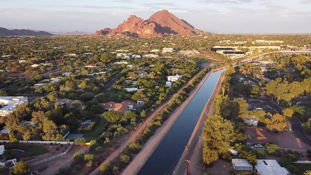 Aerial footage of Phoenix, Arizona with Camelback Mountain glowing red in the evening sun.   
