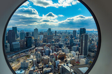 Fototapeta na wymiar Japan. Osaka. View of Osaka from the window. Panorama of Osaka from a height. Island of Honshu. The urban landscape of Japan. Urbanistics. Modern buildings in Japan. House with helipad.