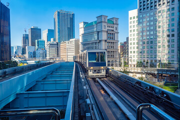 Fototapeta na wymiar Japan. Tokyo. Downtown. The train is close to office buildings. Railways of Japan. Transport in the Japanese city. Urban transport system. Panorama of the city in Japan. Travelling to Tokyo.
