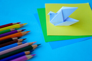 Arrange of pencils color and some origami paper with paper color background. Back to school concept