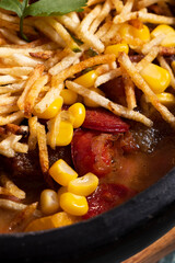 Cazuela de frijoles con arroz, limon, aguacate. Plato tradicional con papa, chorizo, salchicha, maíz y granos. 