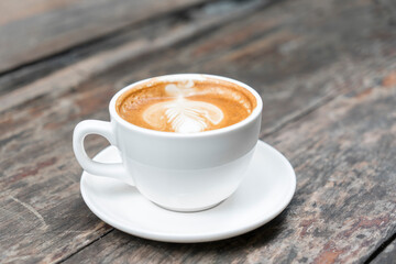 Hot coffee with late art on wooden table