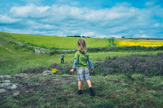 Preschooler boy standing on rocks in the countryside