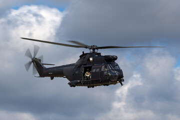 Black military helicopter in flight.