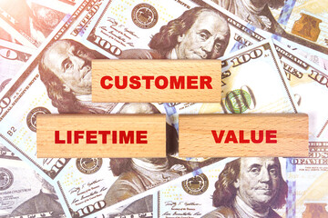 Against the background of dollar bills, the text is written on wooden blocks - customer lifetime value