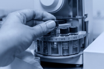 Laboratory concept; close up picture of the scientist put the vial of GC sample on autosampler plate