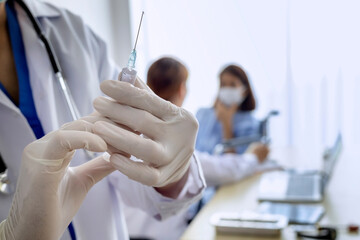 Medical concept; Close up picture of the doctor hold the vaccine syringe with the blurred...
