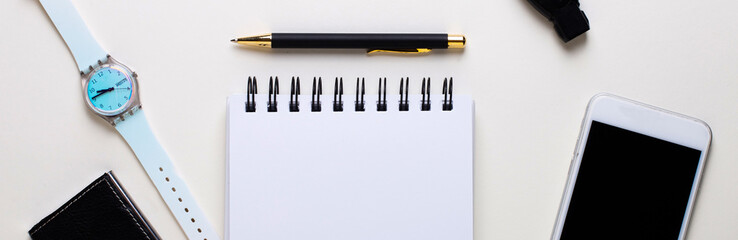 Watch, notebook, pen, smartphone, business card holder lie on a white table. Workplace close-up. View from above. Business concept