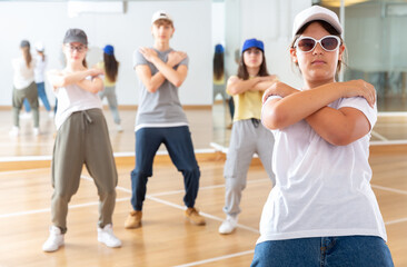 Portrait of emotional girl doing hip hop movements during group class in dance center