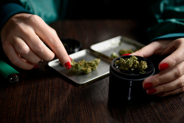 woman with weed in hands nails beautiful style grinder
