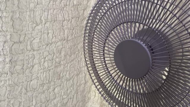 扇風機首振り中。白い扇風機と白いカーテン