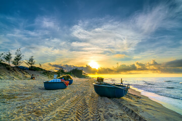 Fototapeta premium Fishing boat to dawn on the beautiful beach on a summer morning on a tropical beach near Mui Ne, Vietnam