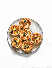 Minced meat, spinach, mozzarella cheese mini hand pies for appetizers, tapas, snack on a light background, top view