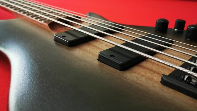Bass guitar body on a red table. Camera pan.