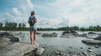 tourist traveler with backpack. hiker view from back looking on hills and mountain river lake, girl...