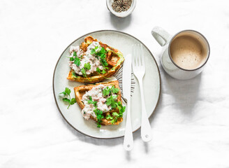 Savory zucchini waffles with tuna, cream cheese pate and coffee on a light background, top view....