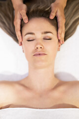 Fototapeta na wymiar Young blond woman receiving a head massage in a spa center.