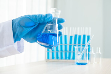 Medical scientists released a sample pipetted into a test flask to analyze the virus in a chemical laboratory. Scientific research concepts