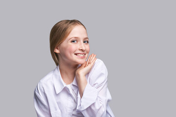 Beauty girl portrait. Young woman. Hand near nead. Face massage concept. White shirt. Cosmetology facelift laser. Medical rejuvenation scrub. Skin care hygiene. Grey background. Smiling