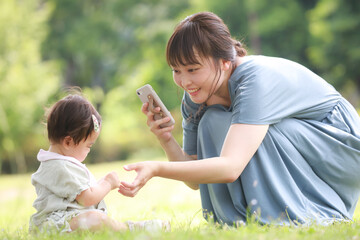 スマートフォンで赤ちゃんを撮影する母親