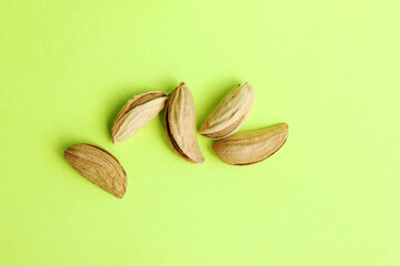 Almonds are not peeled on a yellow background. View from above. Roasted almonds for a snack. Nuts. Food. Quenching hunger. Protein. Nuts in shells. Copy space.