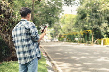 Asian man waiting for Uber taxi