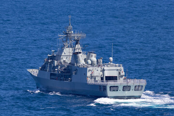 Fototapeta na wymiar Naval vessel heading out to sea.