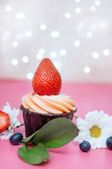 vertical photo birthday cake decorated with large strawberries and cream on a pink background