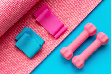 Gymnastic mat, dumbbells and sports gum on blue background, creative flat lay