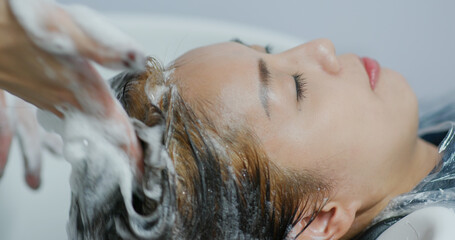 Naklejka premium Woman dye her hair at beauty salon