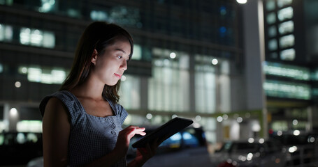 Woman look at tablet computer at night
