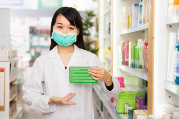 Positive friendly chinese female pharmacist suggesting useful drug.