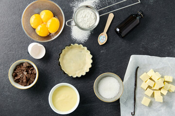 food, culinary and recipe concept - baking dish with dough and cooking ingredients on table