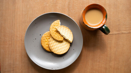 Indian Tea with Biscuits on a plate on wooden background 