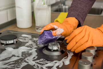 Cleaning in the kitchen gas stone with foam and sponge