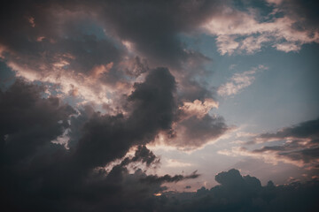Beautiful dramatic sky with dark clouds at sunset, natural abstract background and texture