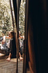 Stylish fashionable blonde woman with smoky eye makeup, in jeans, white t-shirt and black leather jacket on the balcony. Spring autumn fashion concept. Soft selective focus.