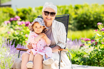 family, generation and people concept - happy grandmother with baby granddaughter at summer garden