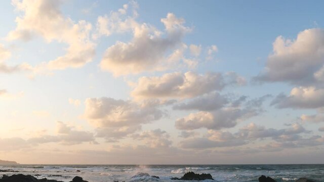 荒れる日本海、夕日に映える流れる雲